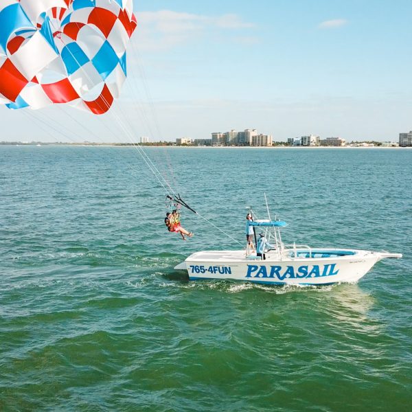 a man flying a kite in a boat on a body of water