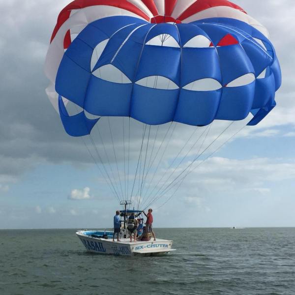 a man flying a kite in a large body of water
